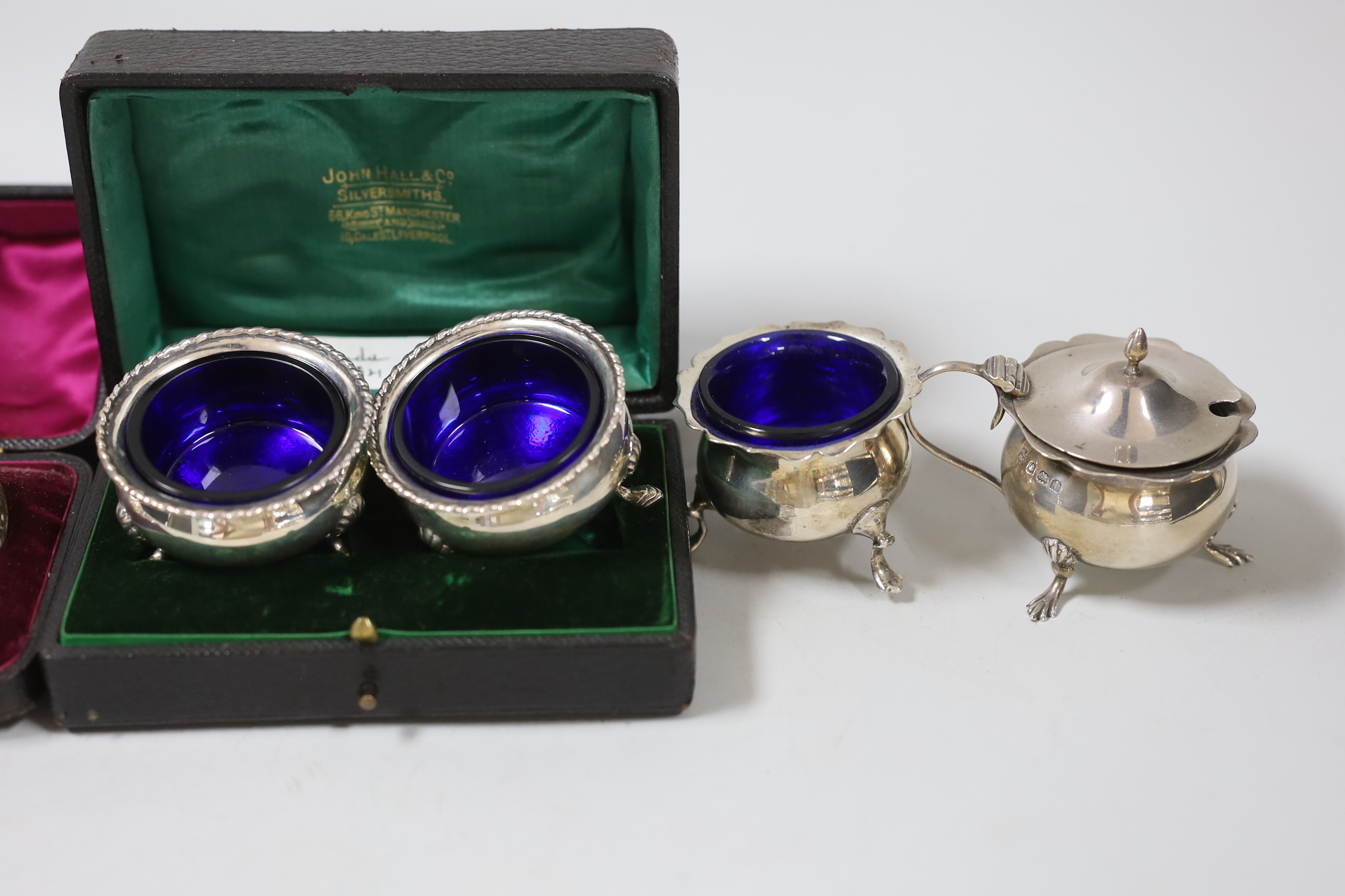 Two cased pairs of silver condiments including chased pepperettes, 45mm and four other silver condiments.